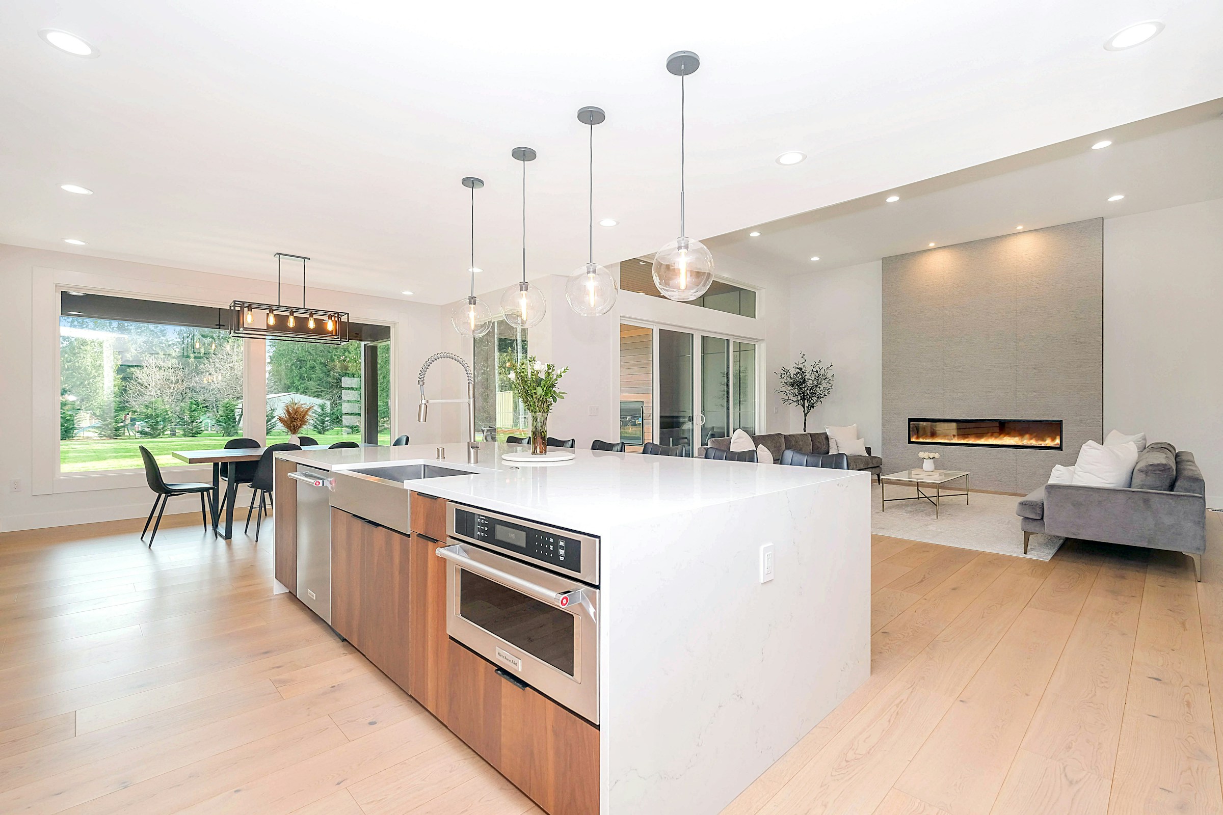 Refined modern kitchen with a waterfall island and warm wood cabinetry