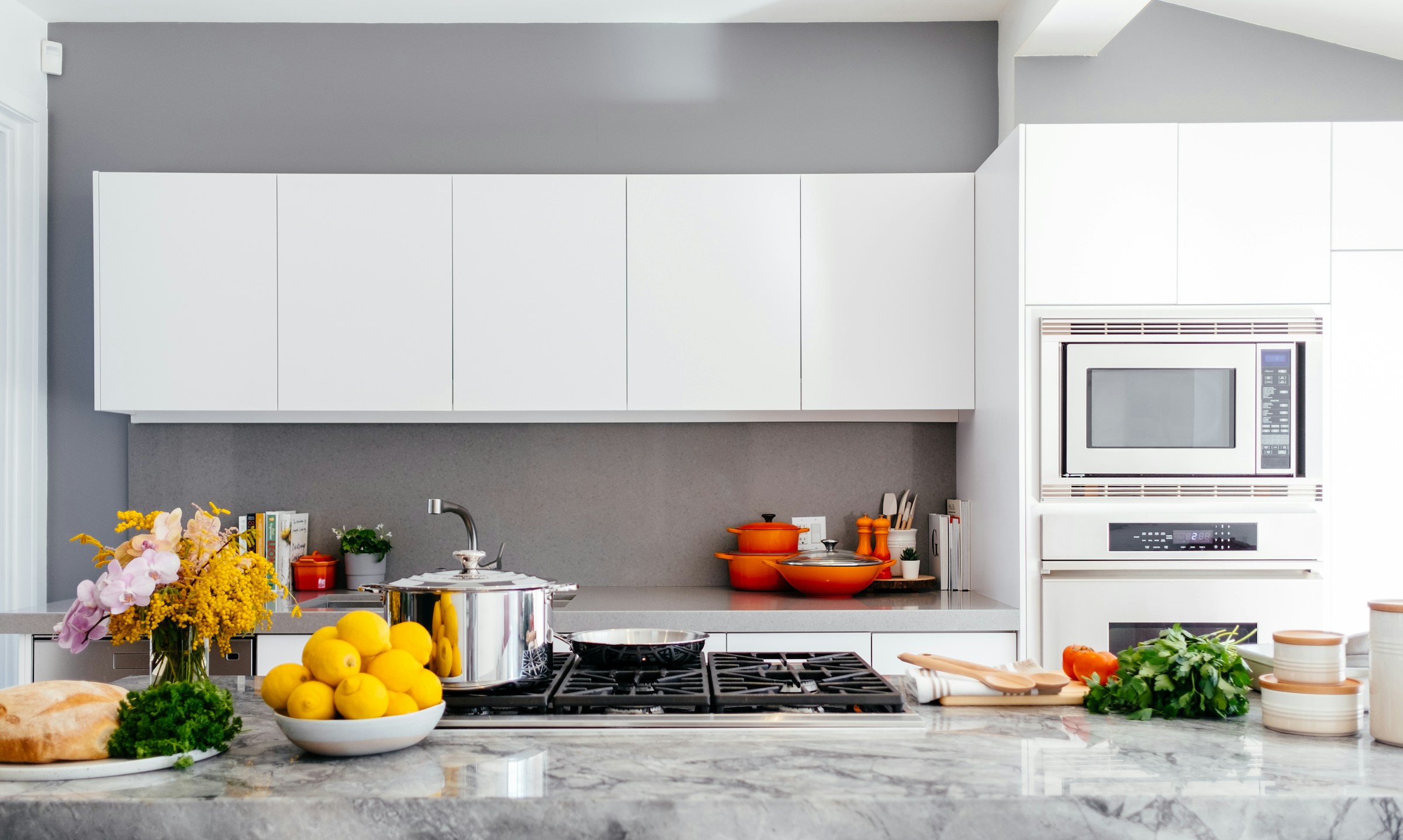 Contemporary white kitchen with a marble worktop and cooking island