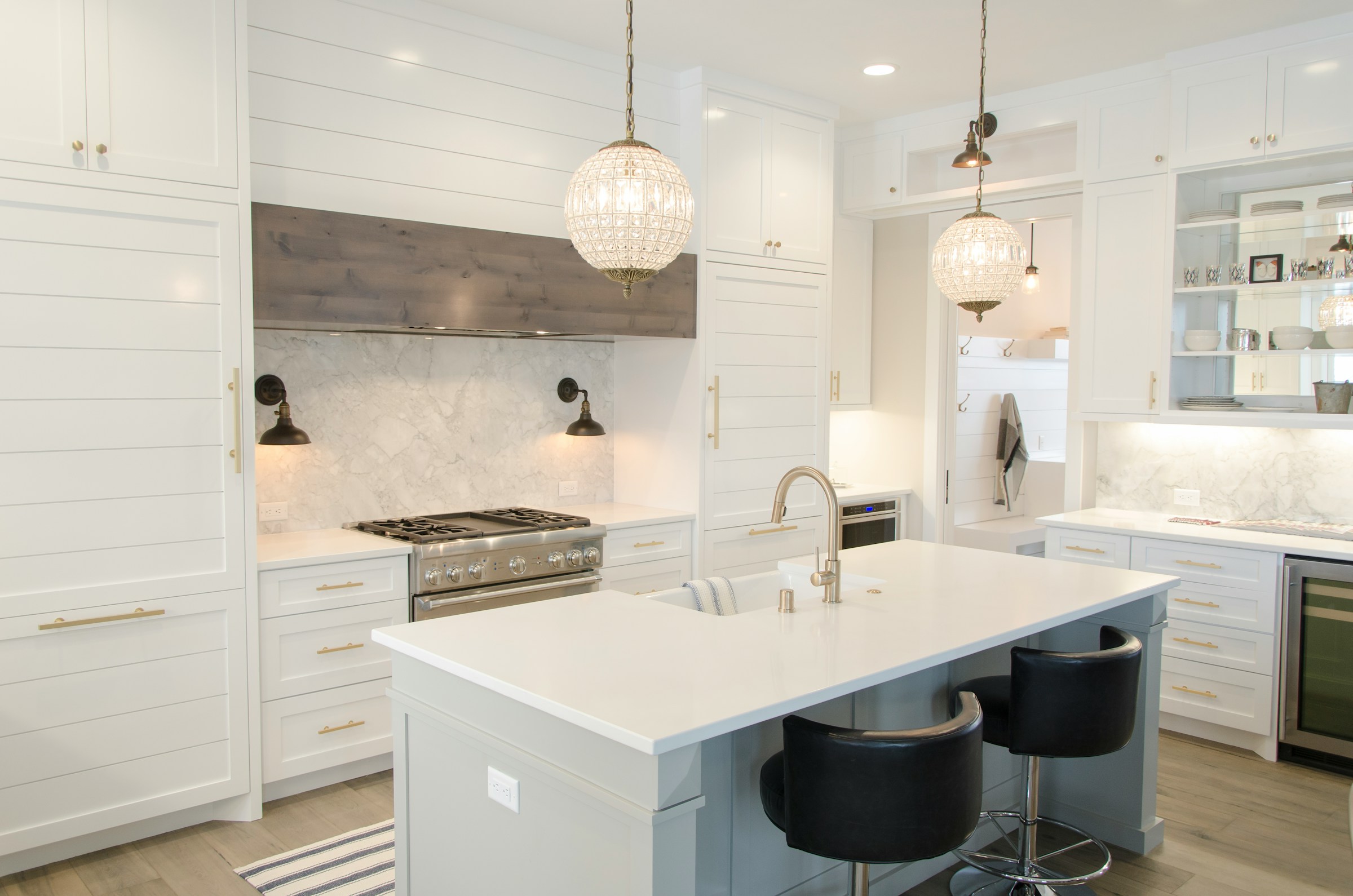 Bright white kitchen with a generous island and brass hardware